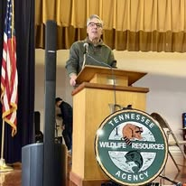Greg Vital speaking at a podium beside a Tennessee Wildlife Resources Agency sign